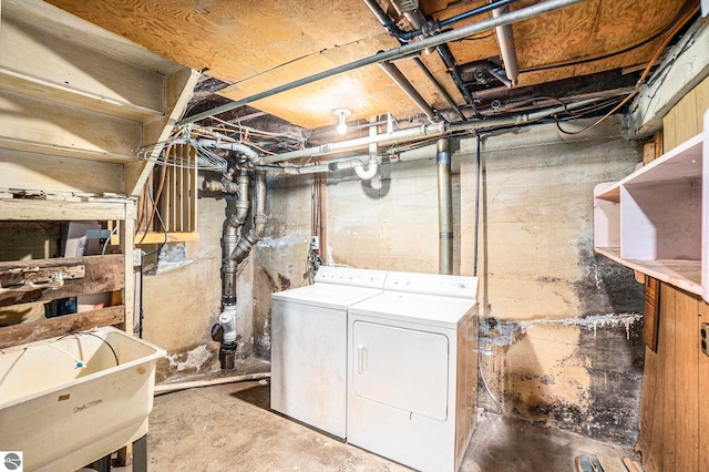 basement featuring independent washer and dryer and sink