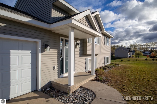 entrance to property with a yard and a garage