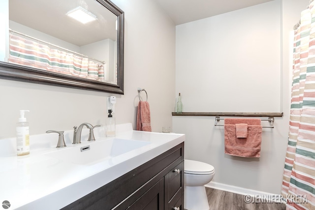 bathroom featuring vanity, hardwood / wood-style flooring, and toilet