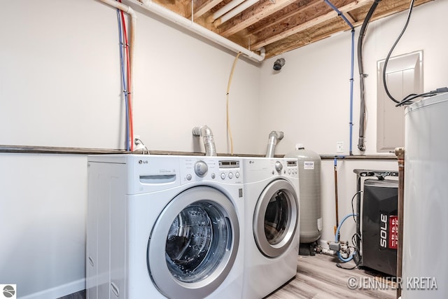 laundry room featuring light hardwood / wood-style floors, washer and clothes dryer, and water heater