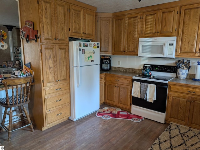 kitchen featuring white appliances, a textured ceiling, and dark hardwood / wood-style floors