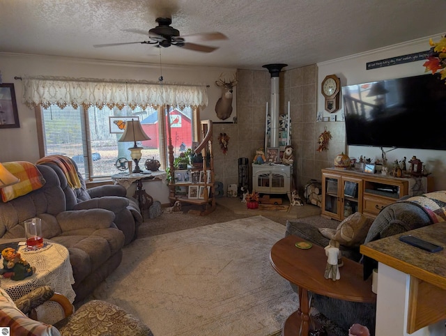 living room featuring ceiling fan, a textured ceiling, tile walls, crown molding, and a wood stove