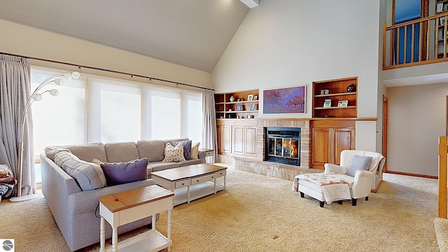 carpeted living room featuring a tiled fireplace, high vaulted ceiling, and built in features