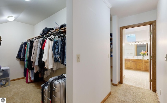 spacious closet with lofted ceiling and light colored carpet