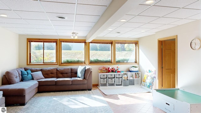 living room featuring a paneled ceiling, beam ceiling, and plenty of natural light