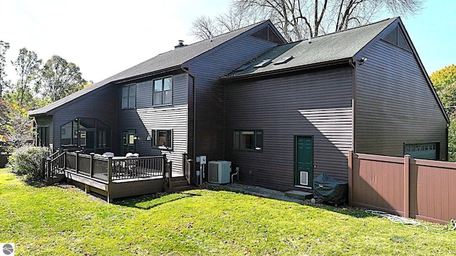 back of house with central AC, a wooden deck, and a lawn