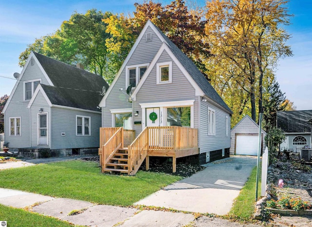 view of front facade with a front yard, a garage, and an outbuilding