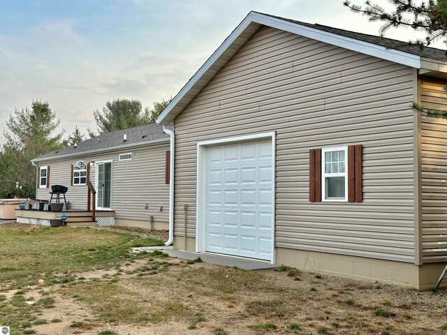 rear view of house with a lawn and a garage