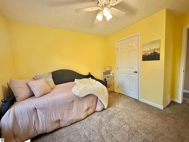 bedroom featuring carpet floors, a textured ceiling, and ceiling fan