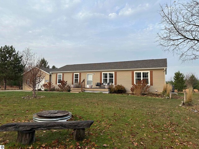 ranch-style home with an outdoor fire pit and a front lawn