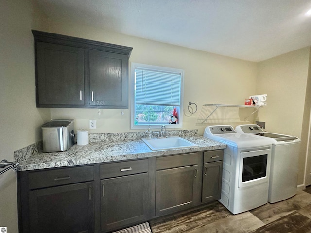 washroom with independent washer and dryer, cabinets, sink, and dark hardwood / wood-style floors