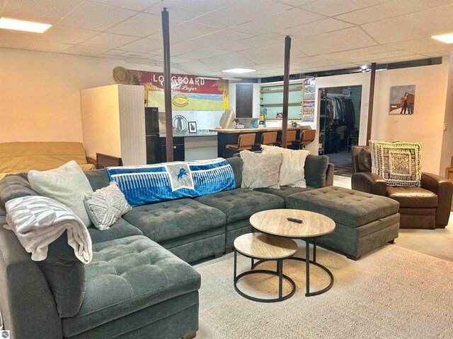 living room with carpet and a drop ceiling