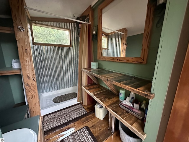 bathroom with curtained shower, wood-type flooring, and toilet