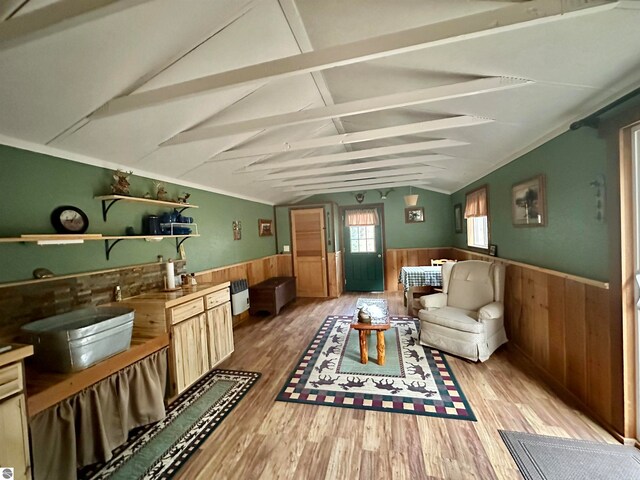 sitting room featuring lofted ceiling with beams, light hardwood / wood-style flooring, and wood walls