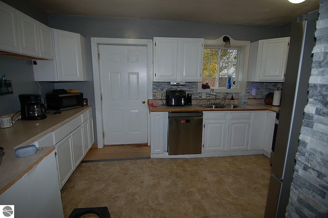 kitchen featuring sink, dishwasher, white cabinets, and decorative backsplash