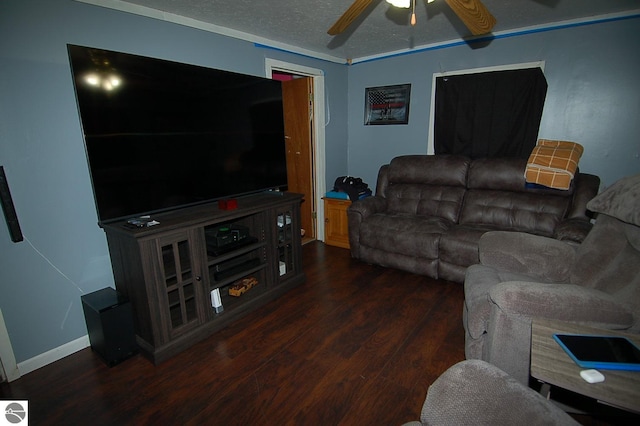 living room featuring ceiling fan, a textured ceiling, dark hardwood / wood-style flooring, and ornamental molding