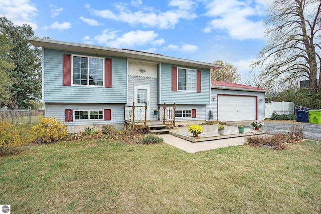 bi-level home featuring a front lawn, a deck, and a garage