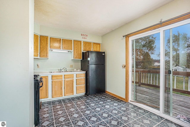 kitchen featuring black appliances, sink, and dark tile patterned floors