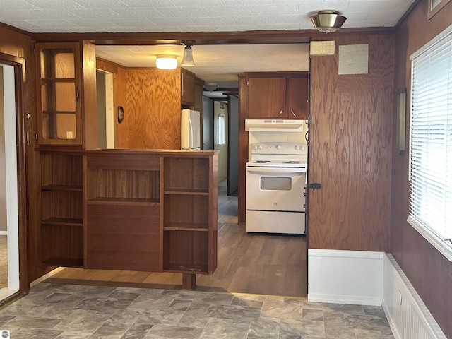 4465 Filter Rd, Harrison, MI 48625 - kitchen with stone finish flooring, brown cabinetry, white appliances, under cabinet range hood, and wooden walls
