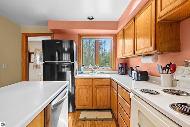 kitchen featuring sink, dishwasher, white electric stove, black fridge, and light hardwood / wood-style floors