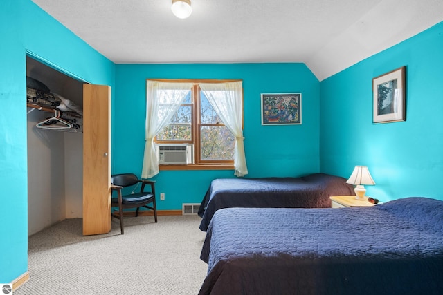 carpeted bedroom with vaulted ceiling, cooling unit, and a closet