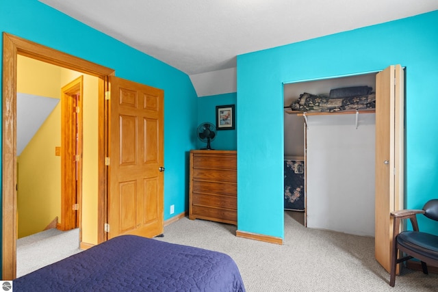 carpeted bedroom with vaulted ceiling and a closet