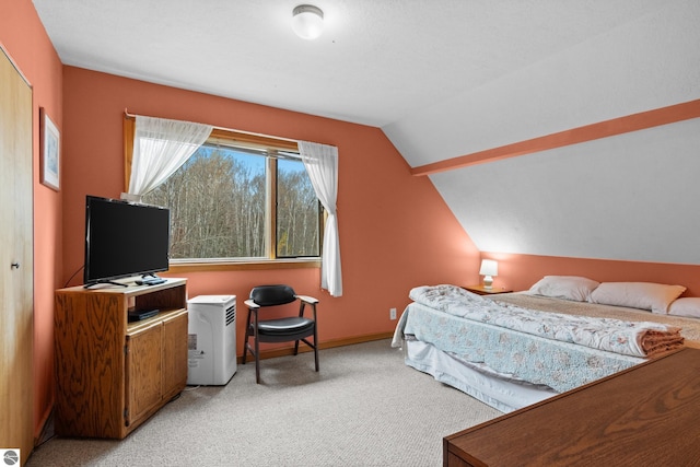 bedroom with lofted ceiling and light colored carpet