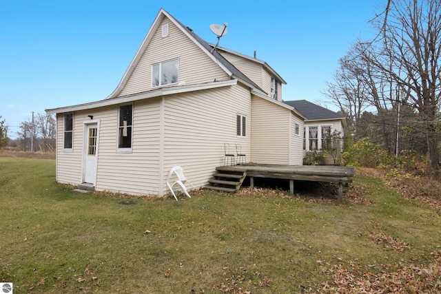 rear view of house featuring a wooden deck and a lawn