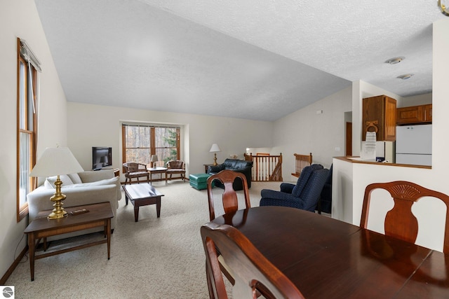 carpeted living room featuring a textured ceiling and vaulted ceiling