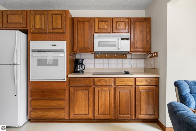 kitchen with backsplash, a textured ceiling, and white appliances