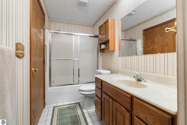 full bathroom featuring vanity, a textured ceiling, shower / bath combination with glass door, tile patterned flooring, and toilet