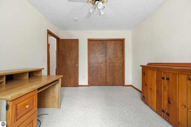 carpeted office with a textured ceiling and ceiling fan