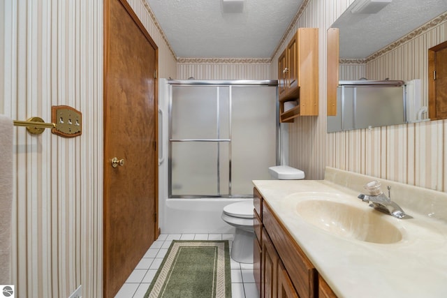 full bathroom featuring tile patterned floors, vanity, a textured ceiling, shower / bath combination with glass door, and toilet