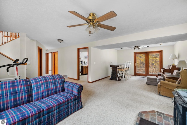 living room featuring ceiling fan and a textured ceiling