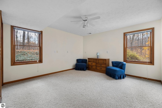 sitting room with carpet, a textured ceiling, plenty of natural light, and ceiling fan