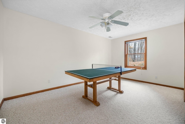 playroom with carpet, a textured ceiling, and ceiling fan