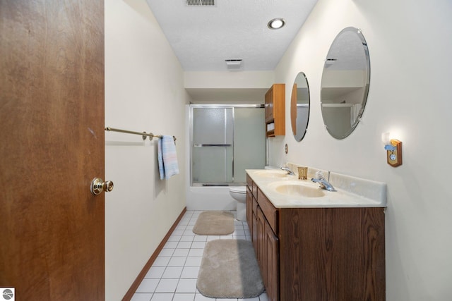 full bathroom with vanity, combined bath / shower with glass door, tile patterned flooring, toilet, and a textured ceiling