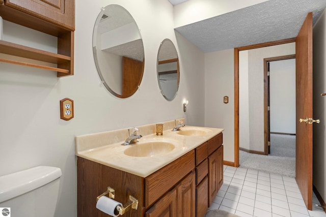 bathroom with tile patterned flooring, vanity, and toilet