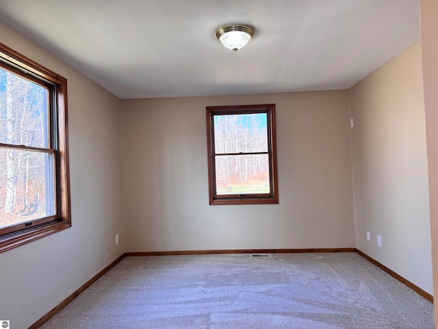 carpeted spare room with a healthy amount of sunlight