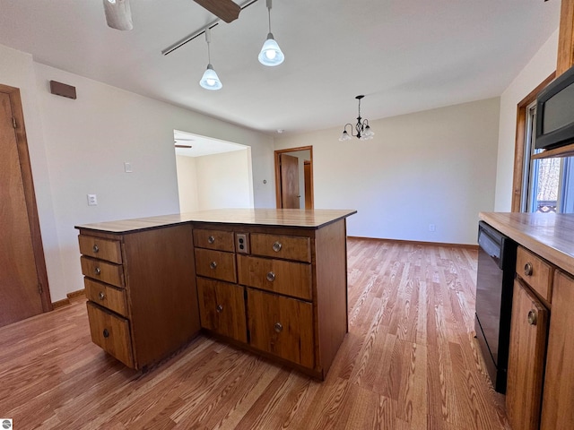 kitchen featuring wood-type flooring, decorative light fixtures, an inviting chandelier, black dishwasher, and a kitchen island