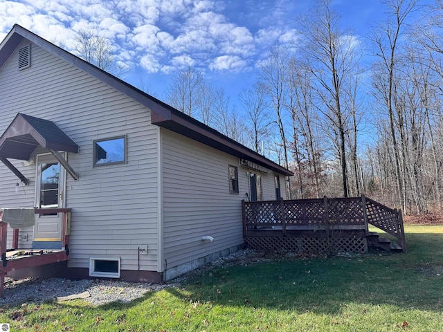 view of side of property featuring a wooden deck and a lawn