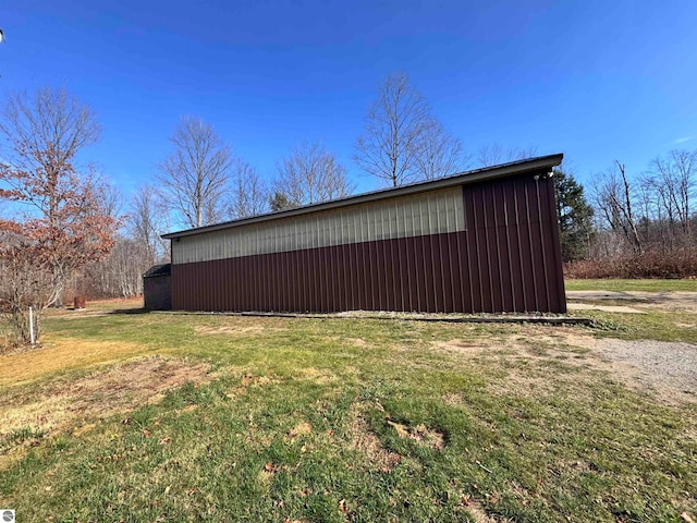 view of side of home with a yard and an outbuilding