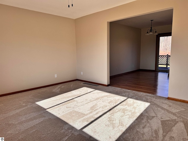 unfurnished room featuring hardwood / wood-style flooring and an inviting chandelier