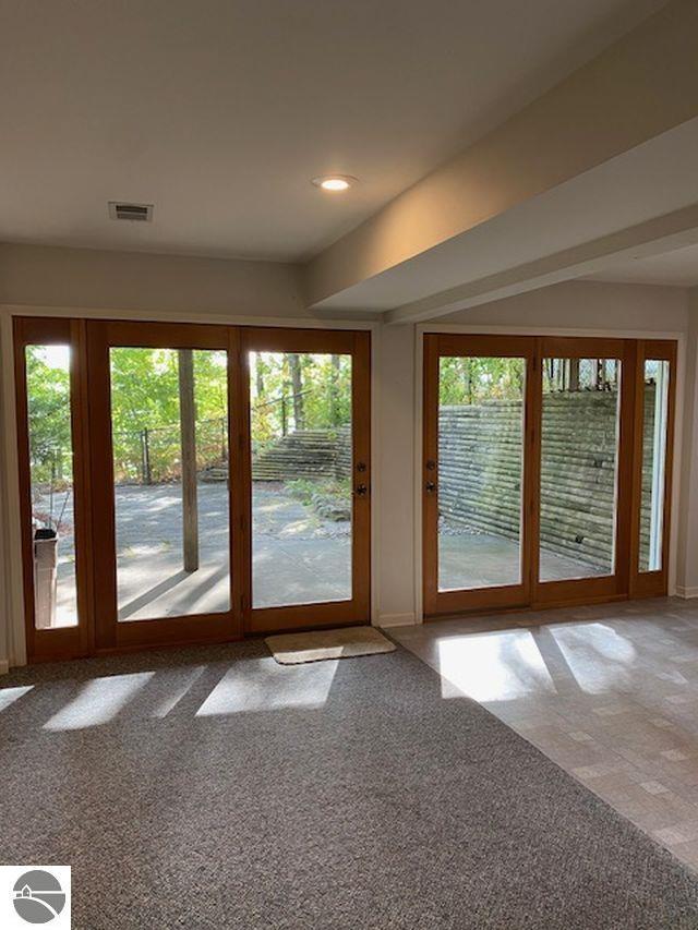 4709 State Park Hwy, Interlochen, MI 49643 - doorway to outside featuring healthy amount of natural light, carpet flooring, baseboards, and recessed lighting