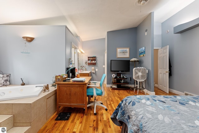 bedroom featuring lofted ceiling and light hardwood / wood-style floors