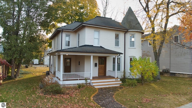 victorian house featuring a front lawn and a porch