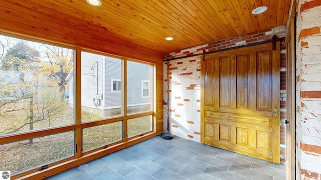 unfurnished sunroom with a barn door and wood ceiling