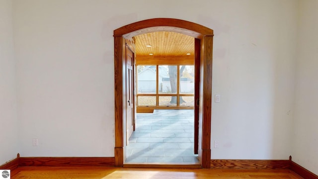 hall with wood ceiling and light wood-type flooring