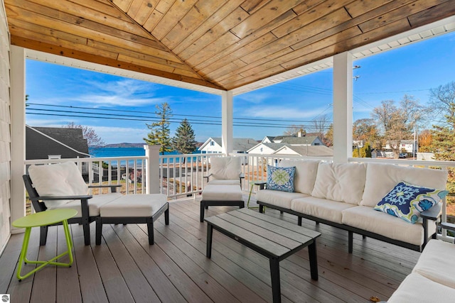 wooden deck with an outdoor living space and a water view