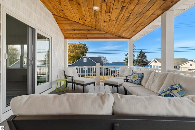 view of patio / terrace with a balcony, a water view, and an outdoor hangout area